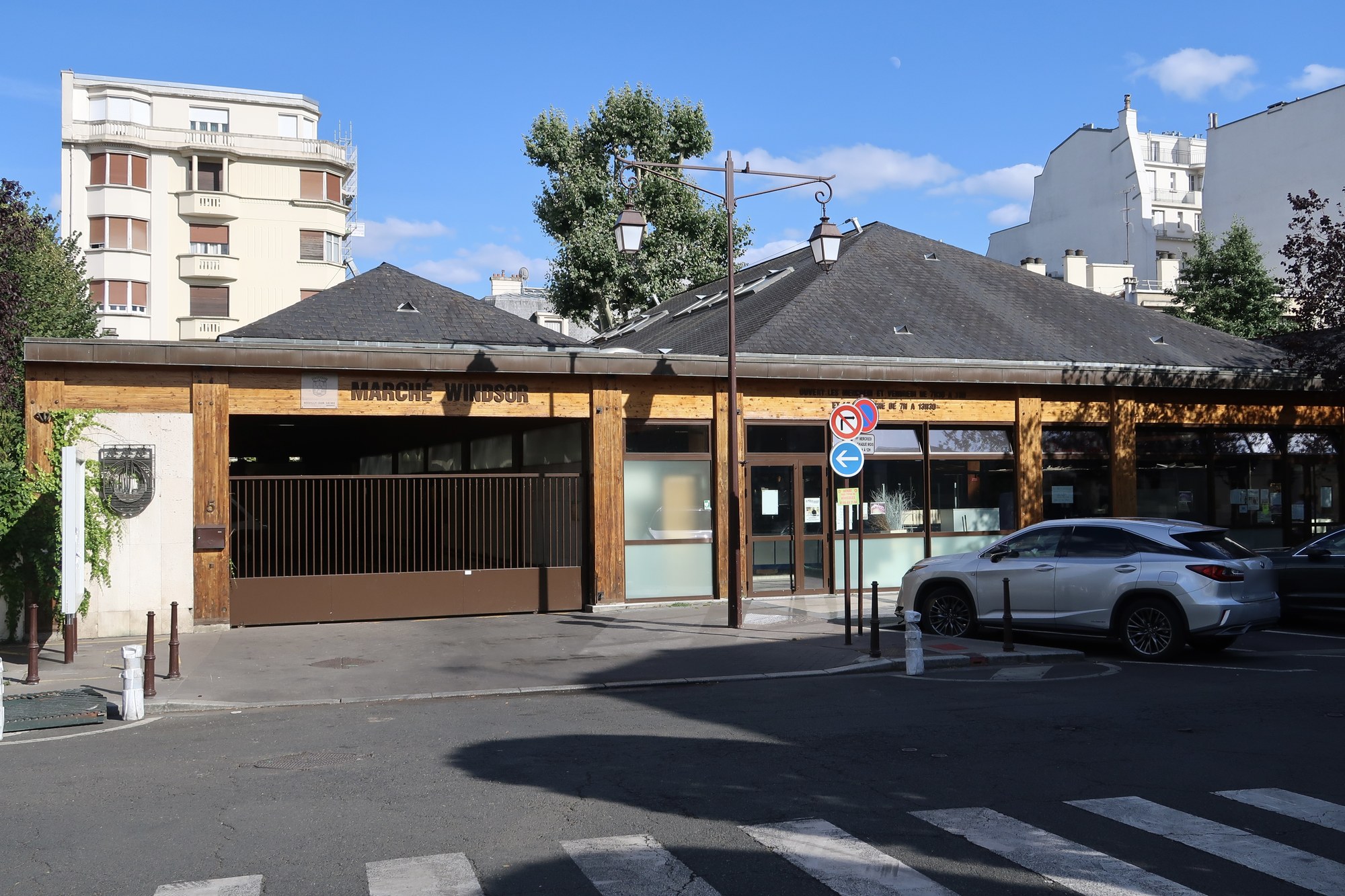 La halle du marché Windsor à Neuilly-sur-Seine sous un ciel d'été, entourée d'immeubles résidentiels