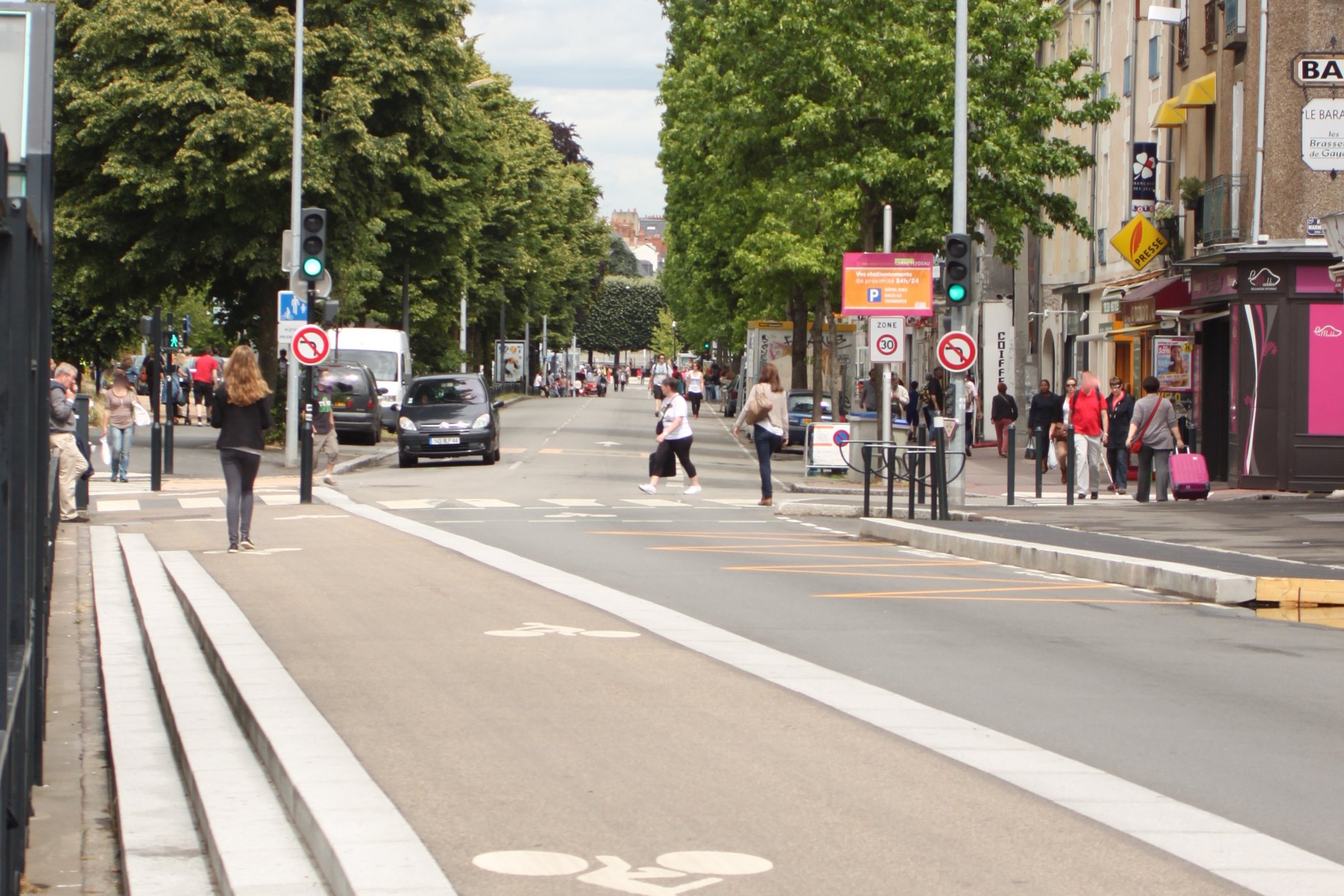 La chaussée de la Madeleine à Nantes : traversées piétonnes, commerces, arbres et piste cyclable